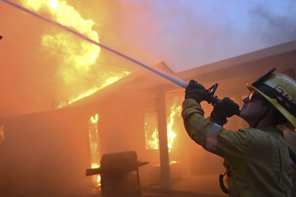 Firefighters battle the Eaton Fire as it engulfs structures Wednesday, Jan. 8, 2025 in Altadena, Calif. (AP Photo/Nic Coury)