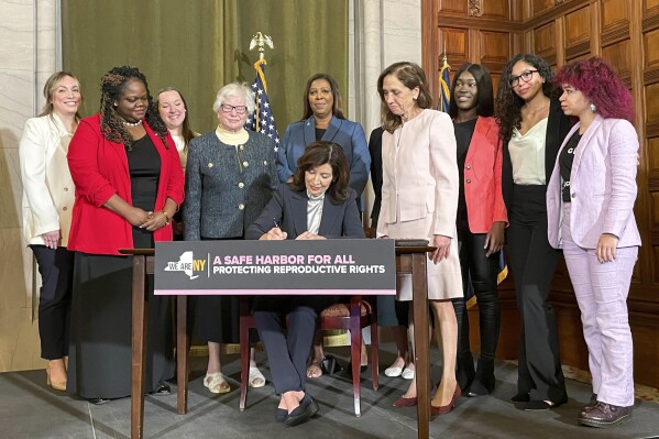 FILE - New York Gov. Kathy Hochul, center, signs bills expanding reproductive healthcare that will allow people in New York to receive contraceptives without a doctor's prescription, May 2, 2023, in Albany, N.Y. New Yorkers will be able to get contraceptives without a prescription under a standing order signed by state health officials on Tuesday, March 19, 2024. The move is part of Hochul's mission to bolster reproductive rights at a time when its restricted in other parts of the country. (AP Photo/Maysoon Khan, File)