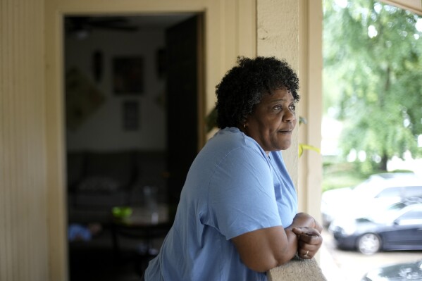 Bobbie Boyd stands outside her apartment Wednesday, Aug. 9, 2023, in Fayetteville, Ark. On a fixed income, Boyd sacrifices meals, health care, and car insurance among other necessities to pay rent and keep cool in the midst of this summer's prolonged heat waves. (AP Photo/Charlie Riedel)