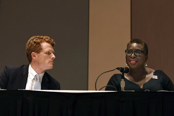 U.S. Rep. Joe Kennedy III, left, listens as Framingham Mayor Yvonne Spicer, right, speaks on a panel on race and politics, Saturday, Sept. 14, 2019, in Springfield, Mass. (AP Photo/Jessica Hill)