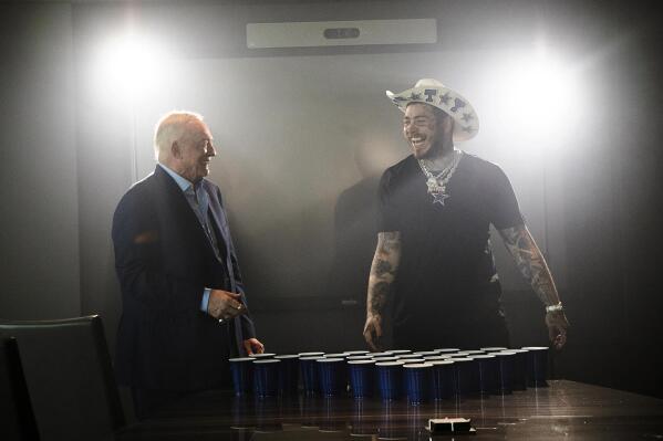 Dallas Cowboys owner Jerry Jones, left, and singer/rapper Post Malone take a break between takes for the 2021 Dallas Cowboys schedule release video at The Star in Frisco, Texas on Friday, April 8, 2021. Schedule release day has become a competition across the NFL between the social media departments of teams to see whose video creates the biggest impression. (Renato Rimach/Dallas Cowboys via AP)