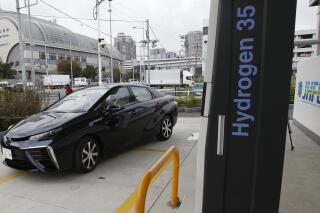 FILE - In this photo taken Nov. 17, 2014, a Toyota Motor Corp.'s new hydrogen fuel cell vehicle Mirai arrives at a charge station near Toyota's showroom in Tokyo. Four Rocky Mountain states announced plans Thursday, Feb. 24, 2022, to cooperate on making the most abundant element in the universe, hydrogen, more readily available and useful as fuel for cars, trucks and industry. (AP Photo/Shizuo Kambayashi, File)