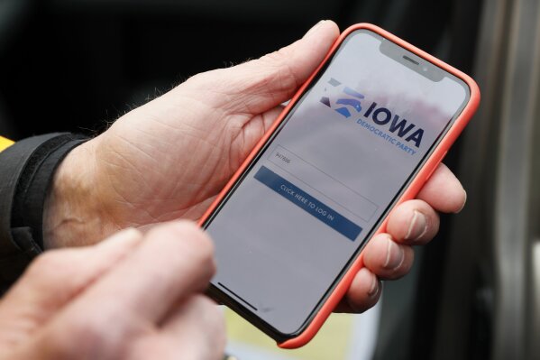 FILE - In this Nov. 15, 2019, file photo, a precinct captain from Des Moines, Iowa, holds his iPhone showing the Iowa Democratic Party’s caucus-reporting app. The botched Iowa caucuses may have been a cautionary tale on the perils of relying on previously unused technology for a grand civic event such as an election or the census. (AP Photo/Charlie Neibergall, File)