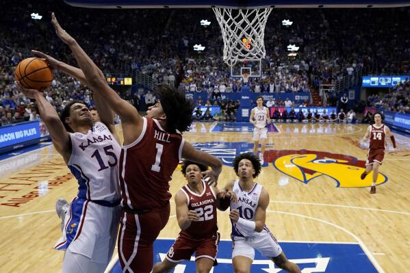 Kansas guard Kevin McCullar Jr. (15) shoots under pressure from Oklahoma forward Jalen Hill (1) during the first half of an NCAA college basketball game Tuesday, Jan. 10, 2023, in Lawrence, Kan. (AP Photo/Charlie Riedel)