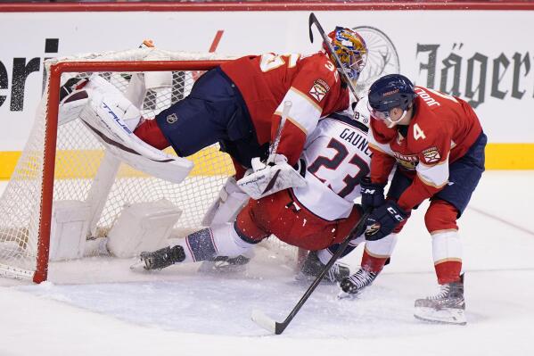 Columbus Blue Jackets center Brendan Gaunce (23) collides with Florida Panthers goaltender Jonas Johansson (35) and defenseman Olli Juolevi (4) during the second period of an NHL hockey game, Thursday, Feb. 24, 2022, in Sunrise, Fla. (AP Photo/Wilfredo Lee)