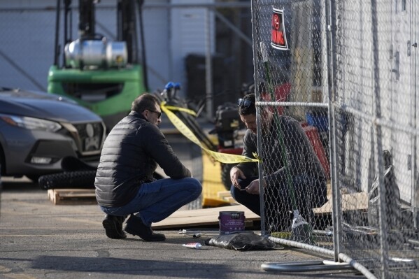 People work at the site of a tent shelter built for migrants in the parking lot of an old CVS store, Thursday, Feb. 1, 2024, in the Little Village neighborhood of Chicago. (AP Photo/Erin Hooley)