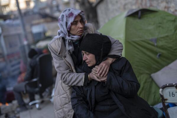 A family mourns moments after a body of a relative was pulled out of a building destroyed during the earthquake in Antakya, southeastern Turkey, Tuesday, Feb. 14, 2023. The death toll from the earthquakes of Feb. 6, that struck Turkey and northern Syria is still climbing. (AP Photo/Bernat Armangue)
