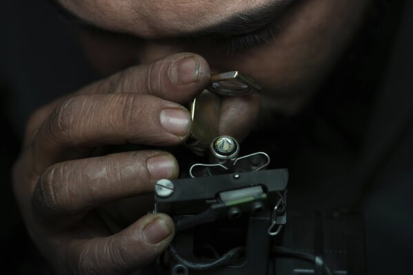 A worker inspects a diamond at Shree Ramkrishna Exports in Surat, India, on April 14, 2025. (AP Photo/Ajit Solanki)