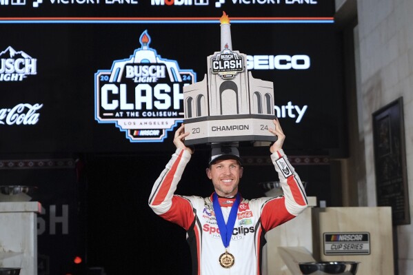 Denny Hamlin poses with his troph after winning the Busch Light Clash NASCAR exhibition auto race at Los Angeles Memorial Coliseum Saturday, Feb. 3, 2024, in Los Angeles. (AP Photo/Mark J. Terrill)