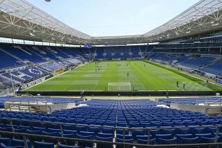 Players of Hoffenheim and Hertha warm-up in the empty stadium prior to the Bundesliga soccer match between TSG 1899 Hoffenheim and Hertha BSC Berlin in Sinsheim, Germany, Saturday, May 16, 2020. The German Bundesliga becomes the world's first major soccer league to resume after a two-month suspension because of the coronavirus pandemic. (Thomas Kienzle/AFP pool via AP)