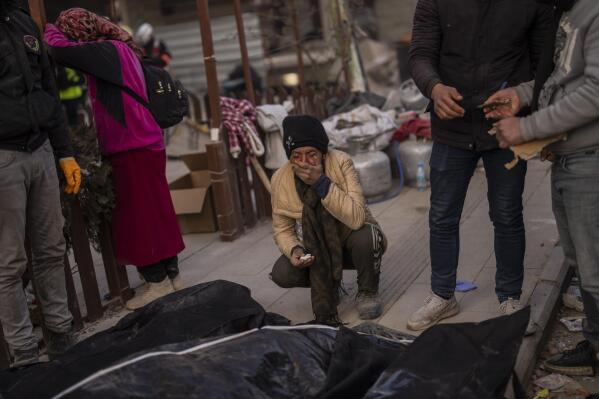 A family mourns next to bodies of relatives that were pulled from the rubble of a destroyed building in Antakya, southeastern Turkey, Wednesday, Feb. 15, 2023. The earthquakes that killed more than 39,000 people in southern Turkey and northern Syria is producing more grieving and suffering along with extraordinary rescues and appeals for aid. (AP Photo/Bernat Armangue)