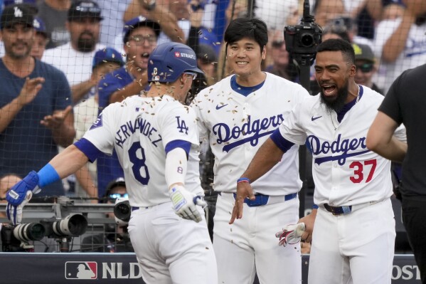 Los Angeles Dodgers' Kiké Hernández (8) celebrates his solo home run with Shohei Ohtani, center, and Teoscar Hernández during the second inning in Game 5 of a baseball NL Division Series against the San Diego Padres, Friday, Oct. 11, 2024, in Los Angeles. (AP Photo/Mark J. Terrill)