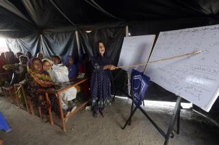 Niños afectados por las inundaciones asisten a una clase organizada por el grupo islámico Jamaat-e-Islami Pakistan, en Sukkur, Pakistán, el domingo 4 de septiembre de 2022. Las autoridades paquistaníes advirtieron el domingo que se esperaban nuevas inundaciones, ya que el lago Manchar, en el sur del país, había crecido por las lluvias monzónicas sin precedentes iniciadas a mediados de junio, y que han dejado casi 1.300 muertos. (AP Foto/Fareed Khan)