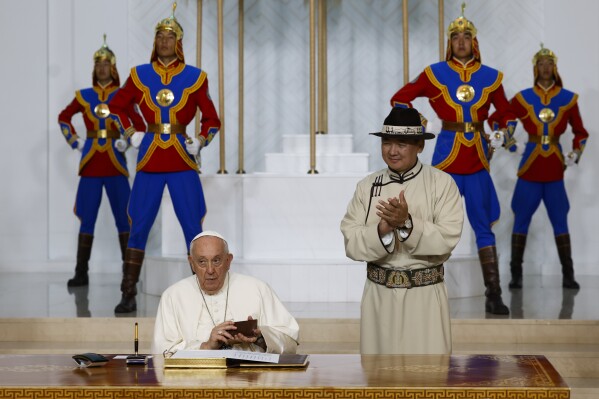 CORRECTS SPELLING OF MONGOLIAN PRESIDENT'S FIRST NAME - Mongolian President Ukhnaagiin Khurelsukh, right, claps his hands at Pope Francis signing the honor book as they meet, Saturday, Sept. 2, 2023, at the State Palace in Sukhbaatar Square in Ulaanbaatar. Pope Francis arrived in Mongolia on Friday morning for a four-day visit to encourage one of the world's smallest and newest Catholic communities. (AP Photo/Remo Casilli, pool)