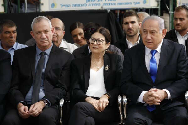 FILE - In this Thursday, Sept. 19, 2019 file photo, Blue and White party leader Benny Gantz, left, Esther Hayut, the Chief Justice of the Supreme Court of Israel, and Prime Minister Benjamin Netanyahu attend a memorial service for former President Shimon Peres in Jerusalem. Israel's two largest political parties are meeting to discuss the possibility of forming a unity government between them, after last week's deadlocked national elections.  The Sept. 23 meeting comes a day after Blue and White leader Benny Gantz and Prime Minister Benjamin Netanyahu of the rival Likud party held their first meeting since the polling.(AP Photo/Ariel Schalit, File)