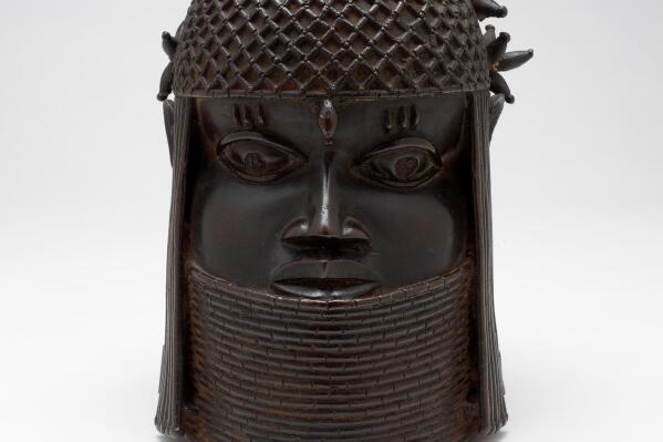 A bronze sculpture called the "Head of a King" or "Oba," probably from the 1700s, rests in front of a white background, Dec. 13, 2004, in Providence, R.I. The bronze sculpture, one the Benin Bronzes, of a West African king, had been in the collection of Rhode Island School of Design Museum for more than 70 years. The sculpture was among 31 culturally precious objects that were looted by the British in the late 19th century and were returned to the Nigerian government, Tuesday, Oct. 11, 2022. (Erik Gould/RISD Museum via AP)