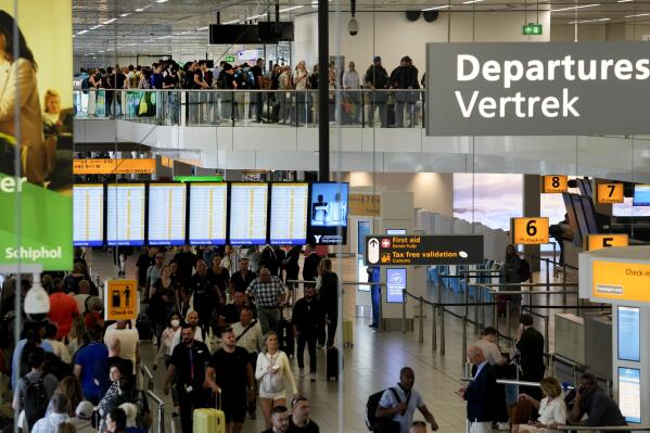 FILE - Travellers wait in long lines to check in and board flights at Amsterdam's Schiphol Airport, Netherlands, on June 21, 2022. Amsterdam's Schiphol airport reported a net profit Friday Aug. 26, 2022, of 65 million euros ($64.8 million) in the first six months of the year as passenger numbers soared despite staff shortages that led to huge lines and piles of unclaimed luggage. (AP Photo/Peter Dejong, File)