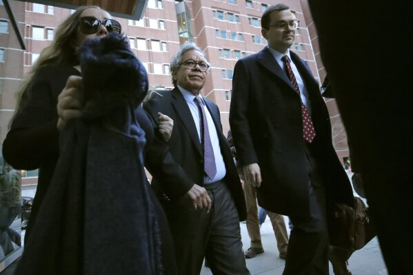 Insys Therapeutics founder John Kapoor, center, departs federal court Thursday, Jan. 23, 2020, in Boston, after he was sentenced to 5 1/2 years in prison for orchestrating a bribery and kickback scheme prosecutors said helped fuel the opioid crisis. He was found guilty the previous May of racketeering and conspiracy in a scheme where millions of dollars in bribes were paid to doctors across the United States to prescribe the company's highly addictive oral fentanyl spray, known as Subsys. (AP Photo/Charles Krupa)