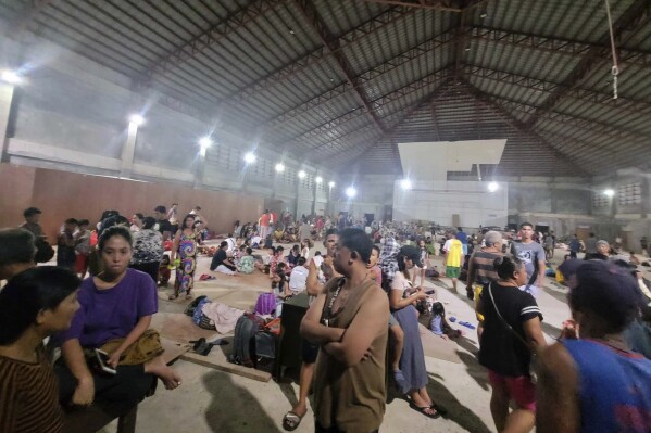 In this photo released by the Local Government Unit of Hinatuan, villagers stay inside a temporary evacuation center at Hinatuan town, Surigao del Sur province, southern Philippines, late Saturday, Dec. 2, 2023. A powerful earthquake struck Saturday off the southern Philippine coast, prompting many villagers to flee their homes in panic after Philippine authorities issued a tsunami warning. (Local Government Unit of Hinatuan via AP)