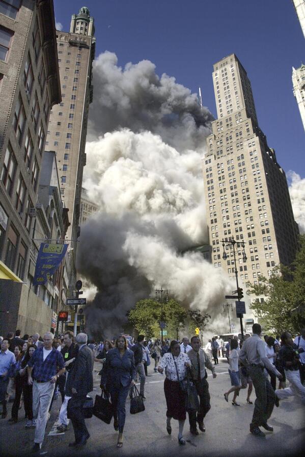 People flee the falling South Tower of the World Trade Center on Tuesday, Sept. 11, 2001. (AP Photo/Amy Sancetta)
