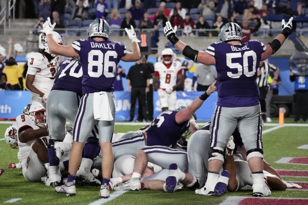 Kansas State tight end Garrett Oakley (86) and offensive lineman Cooper Beebe (50) signal 
