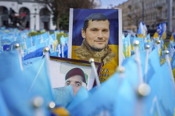 Photographs of fallen Ukrainian servicemen are placed at a memorial in Independence Square, in Kyiv, Ukraine, Wednesday, April 3, 2024. Ukraine on Wednesday lowered the military conscription age from 27 to 25 in an effort to replenish its depleted ranks after more than two years of war following Russia's full-scale invasion. (AP Photo/Vadim Ghirda)