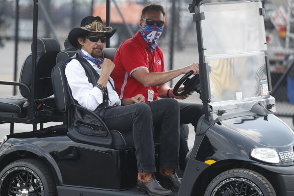 Owner of the race car of Bubba Wallace, former driver Richard Petty, left, rides a golf cart to the garage prior to the NASCAR Cup Series auto race at the Talladega Superspeedway in Talladega Ala., Monday June 22, 2020 (AP Photo/John Bazemore)