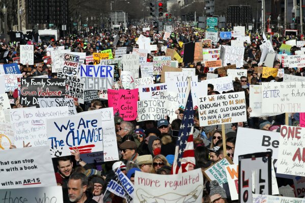 
              Crowds of people hold signs on Pennsylvania Avenue at the "March for Our Lives" rally in support of gun control, Saturday, March 24, 2018, in Washington. (AP Photo/Alex Brandon)
            