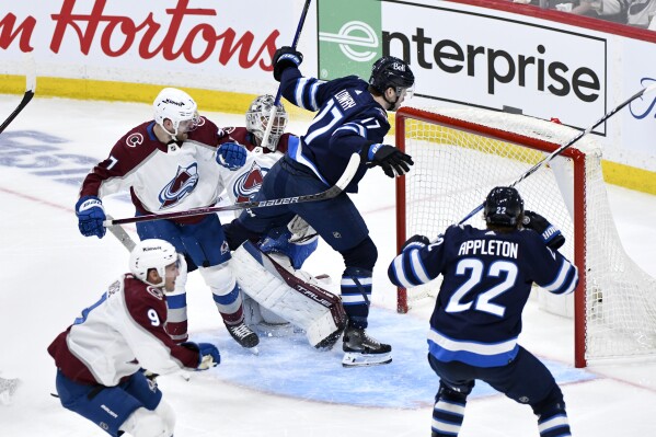 Winnipeg Jets center Adam Lowry (17) scores against Colorado Avalanche goaltender Alexandar Georgiev (40) during the second period in Game 1 of an NHL hockey Stanley Cup first-round playoff series in Winnipeg, Manitoba, Sunday April 21, 2024. (Fred Greenslade/The Canadian Press via AP)