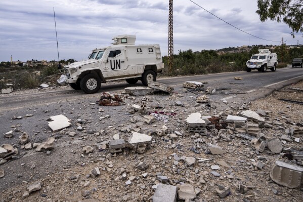 U.N. peacekeepers patrol next to a damage house in the Lebanese side of the Lebanese-Israeli border in the southern village of Marwahin, Lebanon, Saturday, Nov. 25, 2023. With a cautious calm prevailing over the border area in south Lebanon Saturday, the second day of a four-day cease-fire between Hamas and Israel, villages that had emptied of their residents came back to life at least briefly. (AP Photo/Hassan Ammar)