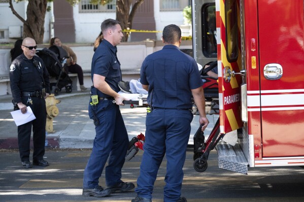 A victim from a brawl and stabbing at Van Nuys High School is taken to a waiting ambulance outside of the school in Los Angeles, Wednesday, Nov. 1, 2023. Three students were found stabbed and the suspect remained on the loose, authorities said. (David Crane/Los Angeles Times via AP)