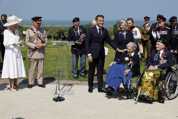 France's President Emmanuel Macron reacts after awarding 104-years-old British World War II veteran Christian Lamb, second right, who helped to plan the D-Day landings in Normandy, with the insignia of Knight in the Legion of Honor order, as Britain's King Charles III and Britain's Queen Camilla, left, looks on during a commemorative ceremony marking the 80th anniversary of the World War II D-Day Allied landings in Normandy, at the World War II British Normandy Memorial of Ver-sur-Mer, Thursday, June 6, 2024. Normandy is hosting various events to officially commemorate the 80th anniversary of the D-Day landings that took place on June 6, 1944. (Ludovic Marin/Pool via AP)