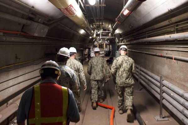 FILE - In this file photo provided by the U.S. Navy, Rear Adm. John Korka, Commander, Naval Facilities Engineering Systems Command (NAVFAC), and Chief of Civil Engineers, leads Navy and civilian water quality recovery experts through the tunnels of the Red Hill Bulk Fuel Storage Facility, near Pearl Harbor, Hawaii, on Dec. 23, 2021. The U.S. military said it's finished draining million of gallons of fuel from the tank complex in Hawaii that poisoned 6,000 people when it leaked jet fuel into Pearl Harbor's drinking water in 2021. (Mass Communication Specialist 1st Class Luke McCall/U.S. Navy via AP, File)