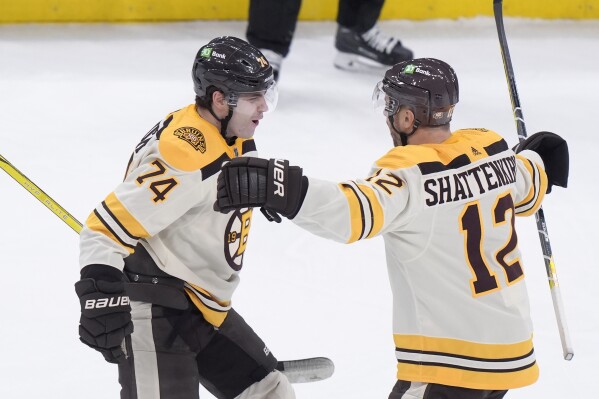Boston Bruins left wing Jake DeBrusk (74) celebrates with defenseman Kevin Shattenkirk (12) after scoring in the first period of an NHL hockey game against the New York Rangers, Thursday, March 21, 2024, in Boston. (AP Photo/Steven Senne)