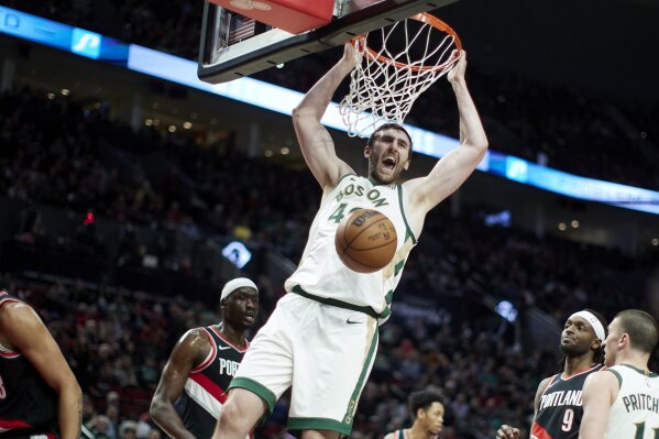 Boston Celtics center Luke Kornet, center, dunks against the Portland Trail Blazers during the first half of an NBA basketball game in Portland, Ore., Monday, March 11, 2024. (AP Photo/Craig Mitchelldyer)