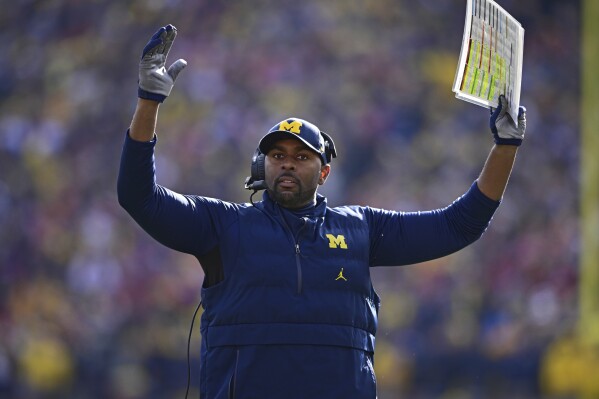 FILE - Michigan acting head coach Sherrone Moore reacts to a video replay during the first half of an NCAA college football game against Ohio State, Saturday, Nov. 25, 2023, in Ann Arbor, Mich. Moore joined a rare group of Black coaches given the opportunity to run elite programs when Michigan hired him to succeed national-championship winning coach Jim Harbaugh. (AP Photo/David Dermer, File)