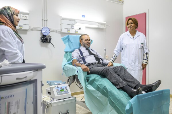 In this photo released by the Royal Palace, Morocco's King Mohammed VI makes a blood donation for the needs of victims of the September 8 earthquake at the "Mohammed VI" University Hospital Center in Marrakech, Morocco, Tuesday Sept. 12, 2023. (Moroccan Royal Palace via AP)