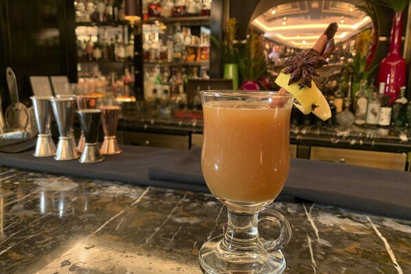In this Wednesday, Dec. 4, 2019 photo, the wassail cocktail is displayed at the Manetta's Bar in Flemings Mayfair Hotel in London.  While mulled wine, warm spiced cider and hot toddies have long been British staples during winter many cocktail bars in London offer their own seasonal winter warmers.  (AP Photo/Louise Dixon)
