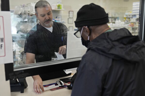 Pharmacist George Tadross, takes care of a customer at MAC Pharmacy, Wednesday, May 29, 2024, in Cleveland. Pharmacists play a role in managing chronic diseases like diabetes and heart-related issues, which Black and Hispanic people are more likely to be diagnosed with. (AP Photo/Sue Ogrocki)