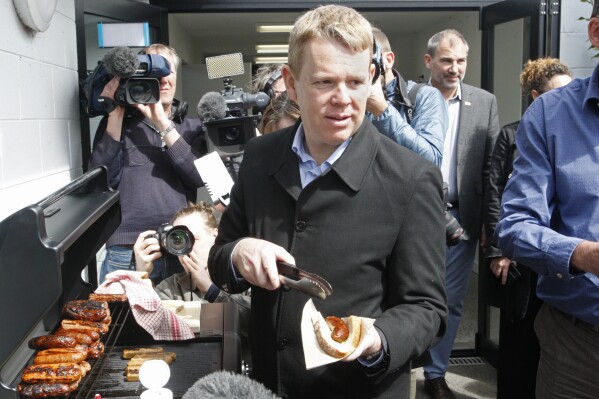 New Zealand's Prime Minister Chris Hipkins hands out sausages on Monday, Sept. 25, 2023, at an event in New Plymouth to promote renewable energy. With less than three weeks to go until a general election, opinion polls have put Hipkins and his Labour Party significantly behind the National Party, led by former businessman Christopher Luxon. (AP Photo/Nick Perry)