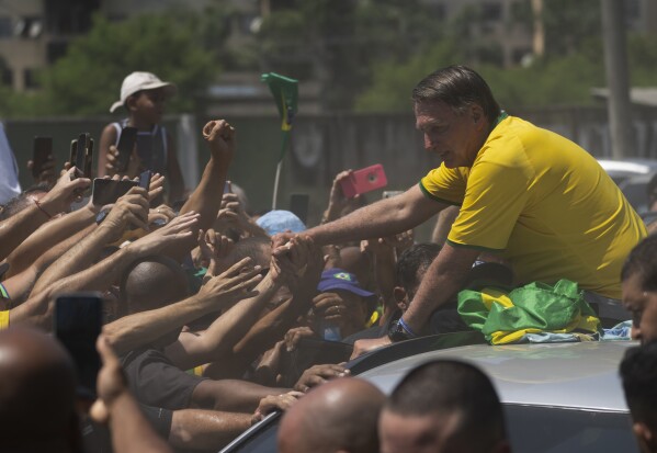 Бывший президент Бразилии Жаир Болсонару приветствует сторонников после начала предвыборной кампании по выдвижению предварительной кандидатуры кандидата в мэры в Рио-де-Жанейро, Бразилия, суббота, 16 марта 2024 года. (AP Photo/Silvia Izquierdo)