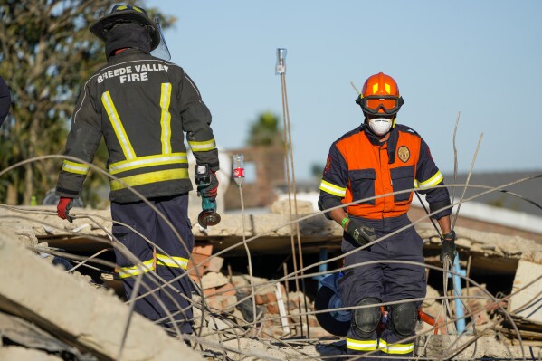 Rescue personnel search the site of a building collapse in George, South Africa, Thursday, May 9, 2024. Rescue teams searching for dozens of construction workers missing after a multi-story apartment complex collapsed in the coastal city have not brought out more survivors in the past 24 hours. (AP Photo/Jerome Delay)