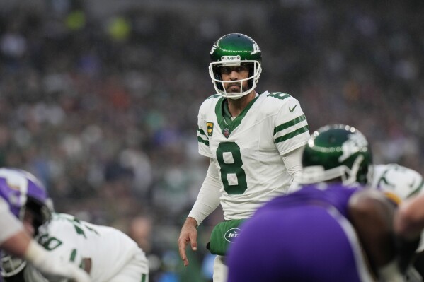 New York Jets quarterback Aaron Rodgers (8) looks out over the line of scrimmage during an NFL football game against the Minnesota Vikings at Tottenham Hotspur Stadium, Oct. 6, 2024 in London. (AP Photo/Steve Luciano, File)