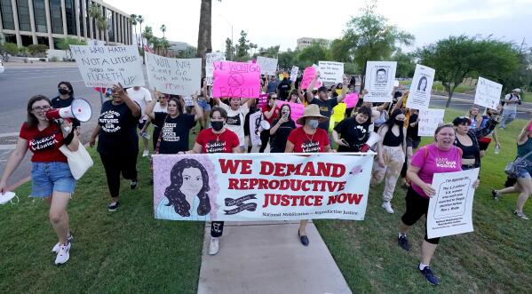 FILE - Thousands of protesters march around the Arizona Capitol in protest after the Supreme Court decision to overturn the landmark Roe v. Wade abortion decision Friday, June 24, 2022, in Phoenix. The U.S. Supreme Court ruling overturning Roe v. Wade has legal advocates, prosecutors and residents of red states facing a legal morass created by decades of often conflicting anti-abortion legislation. In Arizona, Republicans are fighting among themselves over whether a 121-year-old anti-abortion law that precedes statehood should be enforced over a 2022 version. (AP Photo/Ross D. Franklin, File)