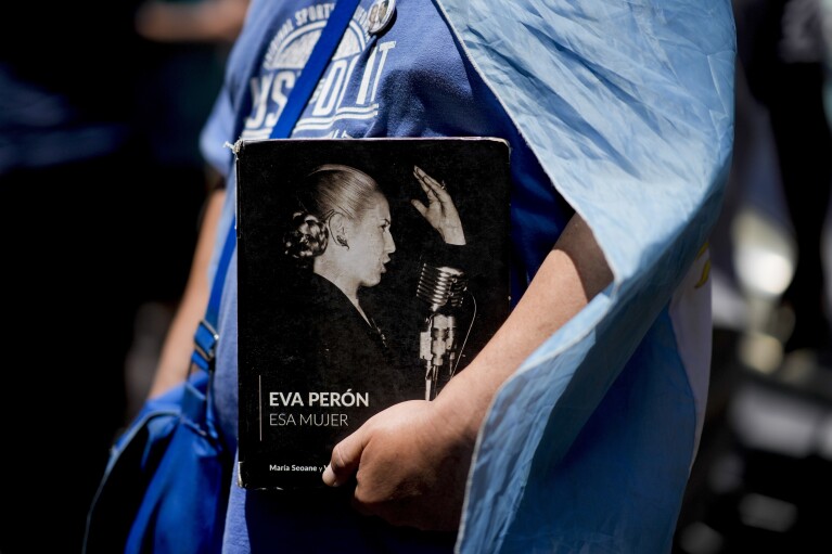 A protester holds a book titled "Eva Peron, That Woman" during a rally against the economic and labor reforms proposed by Argentine President Javier Milei in Buenos Aires, Argentina, Wednesday, Jan. 24, 2024. (AP Photo/Natacha Pisarenko)