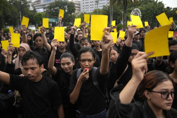 Activists holds yellow cards to symbolize a warning during 'Kamisan', a weekly protest held by the relatives of the victims of human rights violations in Indonesia, outside the presidential palace in Jakarta, Thursday, Feb. 15, 2024. Dozens of activists attended the rally to express disappointment with the quick count results of the elections held in Indonesia where Prabowo Subianto, a former general linked to past human rights abuses, claimed victory according to unofficial tallies conducted by Indonesian polling agencies. President Joko Widodo faces mounting criticism over his lack of neutrality after he threw his support behind Subianto, who has picked Widodo's son as his running mate. (APPhoto/Dita Alangkara)