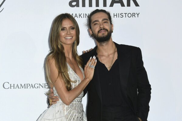 
              FILE - In this May 17, 2018, file photo, model Heidi Klum, left, and musician Tom Kaulitz pose for photographers upon arrival at the amfAR, Cinema Against AIDS, benefit at the Hotel du Cap-Eden-Roc, during the 71st international Cannes film festival, in Cap d'Antibes, southern France.  Klum, a 45-year-old German model, announced her engagement to Tokio Hotel guitarist Kaulitz in an Instagram post on Monday, Dec. 24. (Photo by Arthur Mola/Invision/AP, File)
            