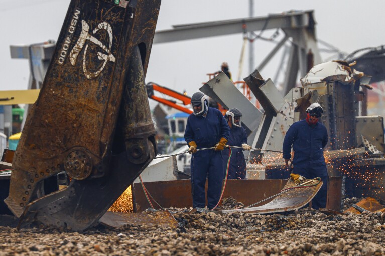 2024 年 4 月 12 日星期五，马里兰州 Sparrows Point，工人们用火把拆解大西洋贸易点倒塌的弗朗西斯·斯科特基大桥的大块残骸（美联社照片/Julia Nikhinson）
