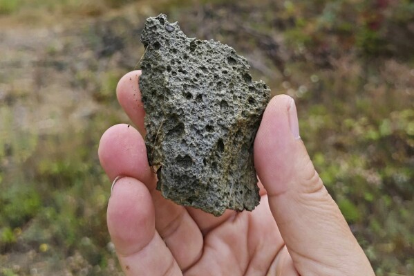 This photo provided by researcher Roman Garba shows a heavily weathered flake artifact at the Korolevo I archaeological site in western Ukraine in August 2023. Stone tools found in the area are the earliest evidence of early human presence in Europe, dating back to 1.4 million years ago, according to research published in the journal Nature on Wednesday, March 6, 2024. (Roman Garba via AP)