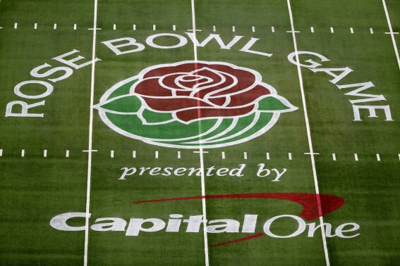 FILE - The Rose Bowl Game logo is displayed on the field at AT&T Stadium before the Rose Bowl NCAA college football game between Notre Dame and Alabama in Arlington, Texas, Jan. 1, 2021. The NCAA will allow commercial sponsor advertisements on football fields for regular-season games in all three divisions beginning this season, creating a new revenue stream for schools facing mounting costs in the changing college sports landscape. The NCAA Playing Rules Oversight Panel on Thursday, June 6, 2024, approved the recommendation from the Football Rules Committee. (AP Photo/Roger Steinman, File)